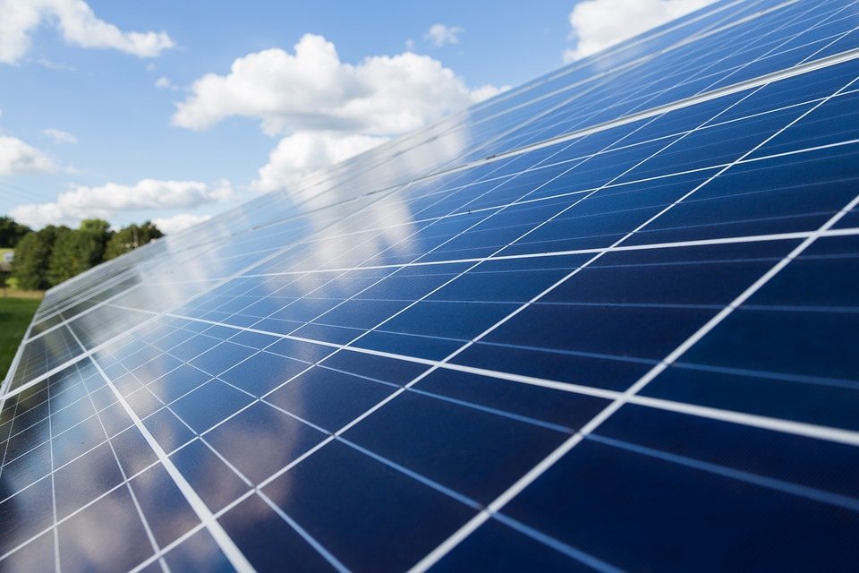 A ground-mounted solar array under a blue sky
